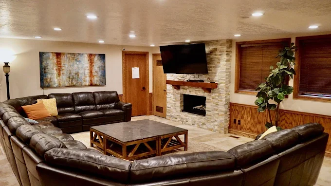 Large leather sectional and flat screen in warm lounge