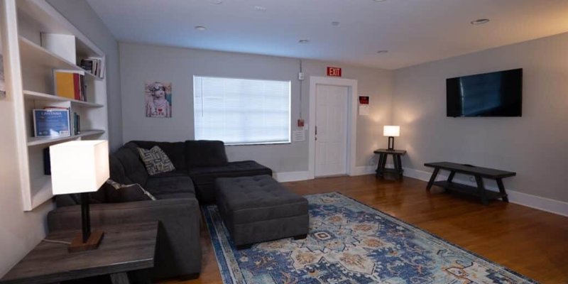 A cozy living room featuring a comfortable sectional sofa, warm lighting, and a large TV, creating a perfect space for relaxation and leisure.