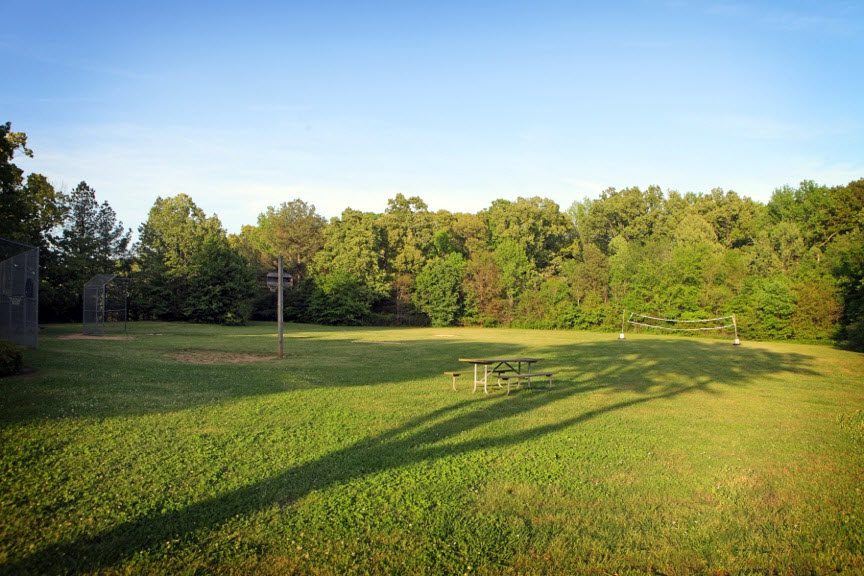 Grassy recreation area with volleyball net and picnic table