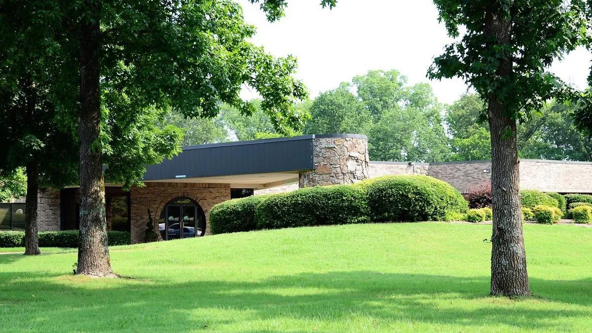 Facility exterior with landscaped lawn and trees