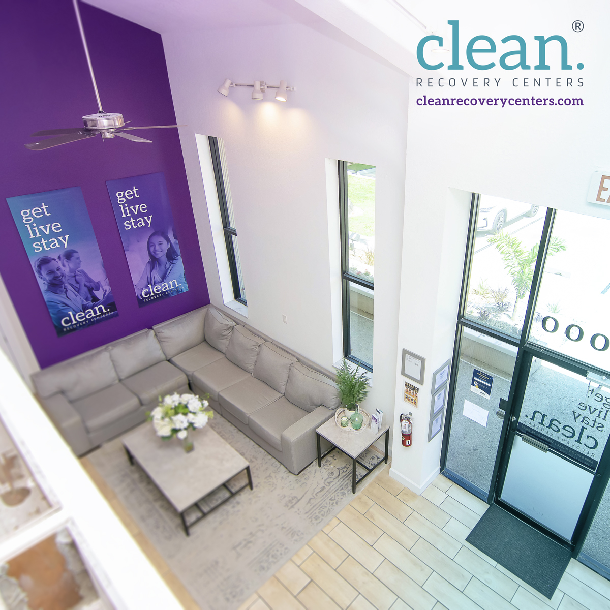 Bright lobby with gray sectional sofa and purple accent wall