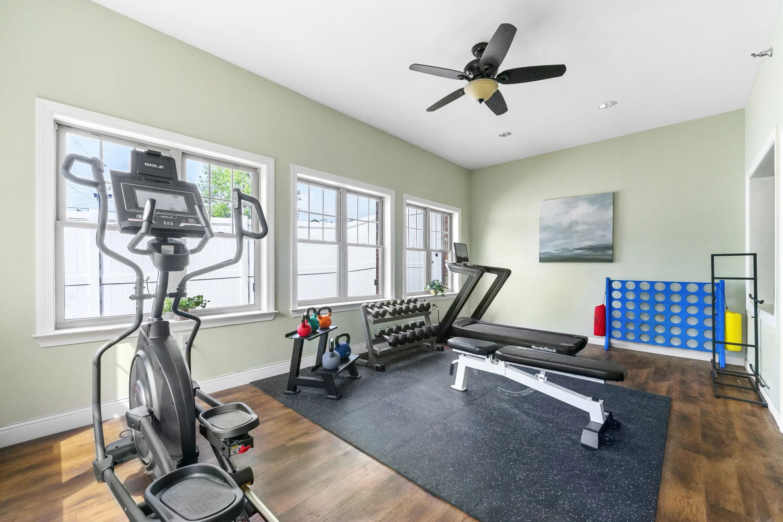 Fitness center featuring cardio equipment, free weights, kettlebells, and strength training equipment