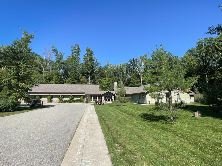 Single-story rehab facility surrounded by trees and open lawn