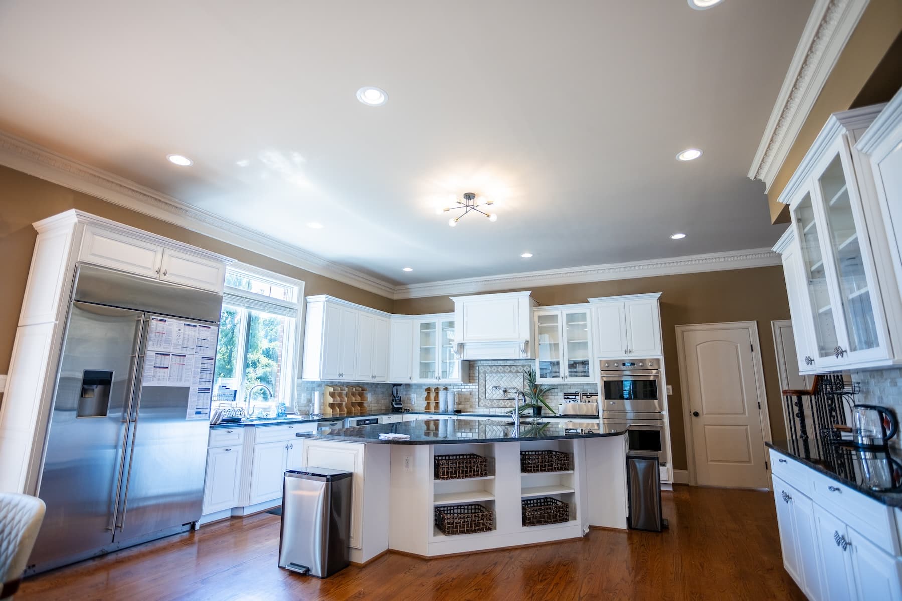 A modern kitchen with white cabinetry and a large center island