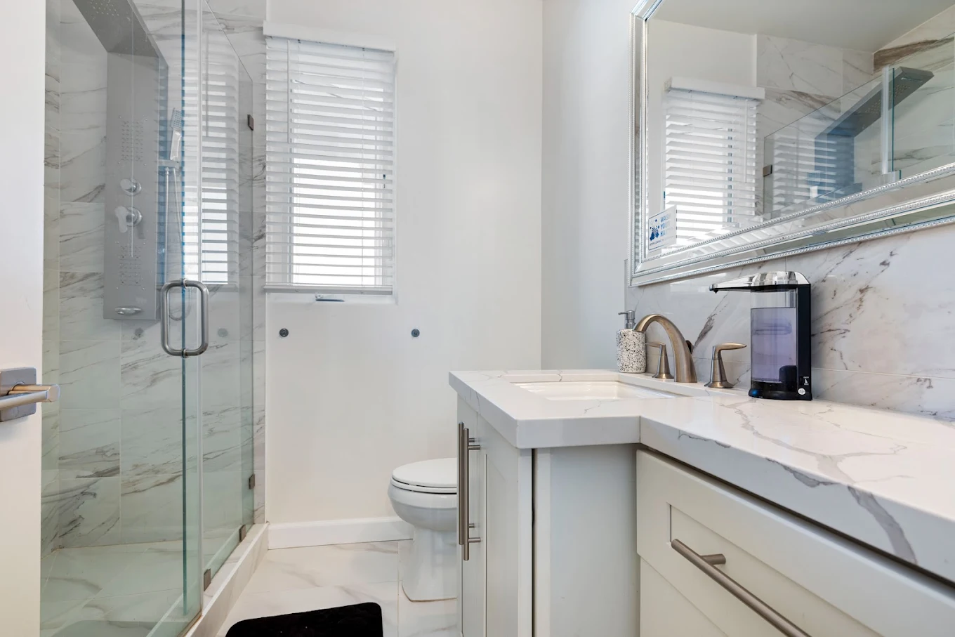 Bathroom with marble vanity and glass shower enclosure