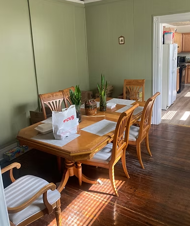Wooden dining table with chairs and plants in a bright room