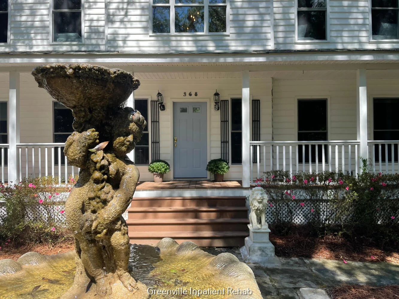 White house entry with fountain and porch