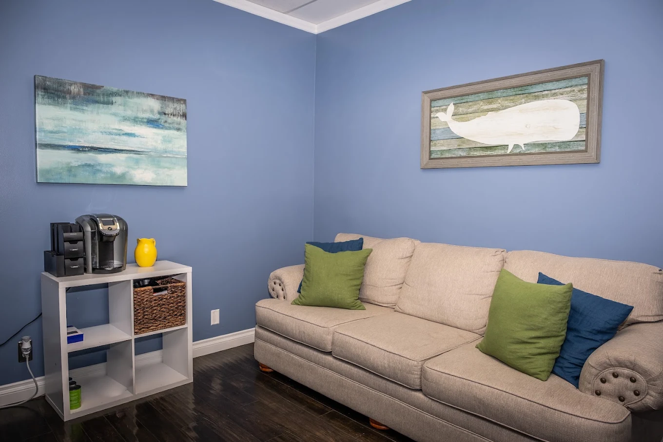 Counseling room with sofa, pillows, artwork, and side table