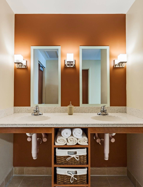 Clean shared bathroom with double sinks and wall mirrors
