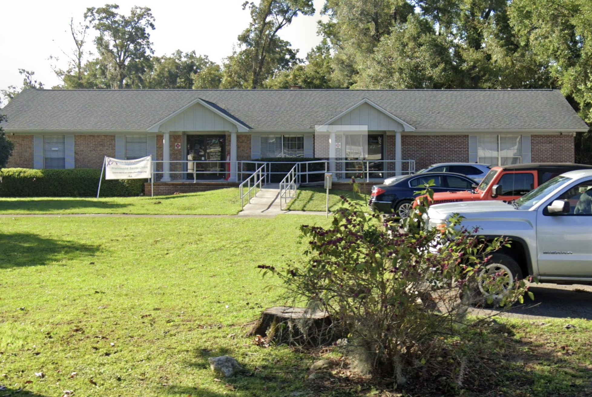 Single-story Disc Village building with ramp and parked cars