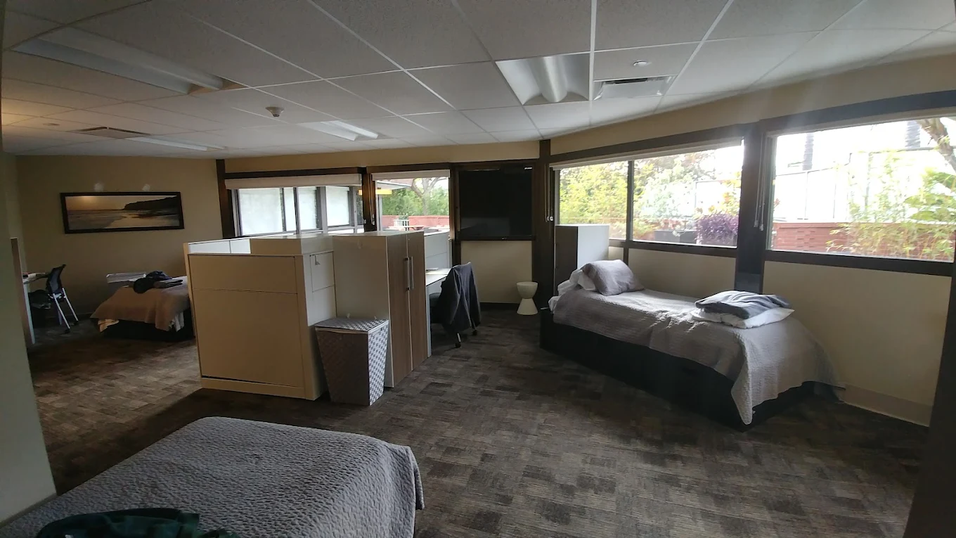 Shared patient bedroom with beds and privacy partitions