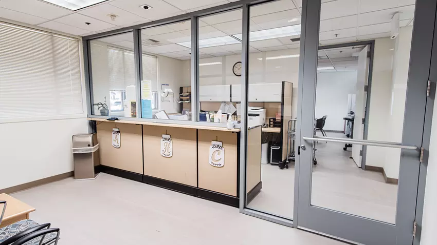 Reception desk and clinic office behind glass partition