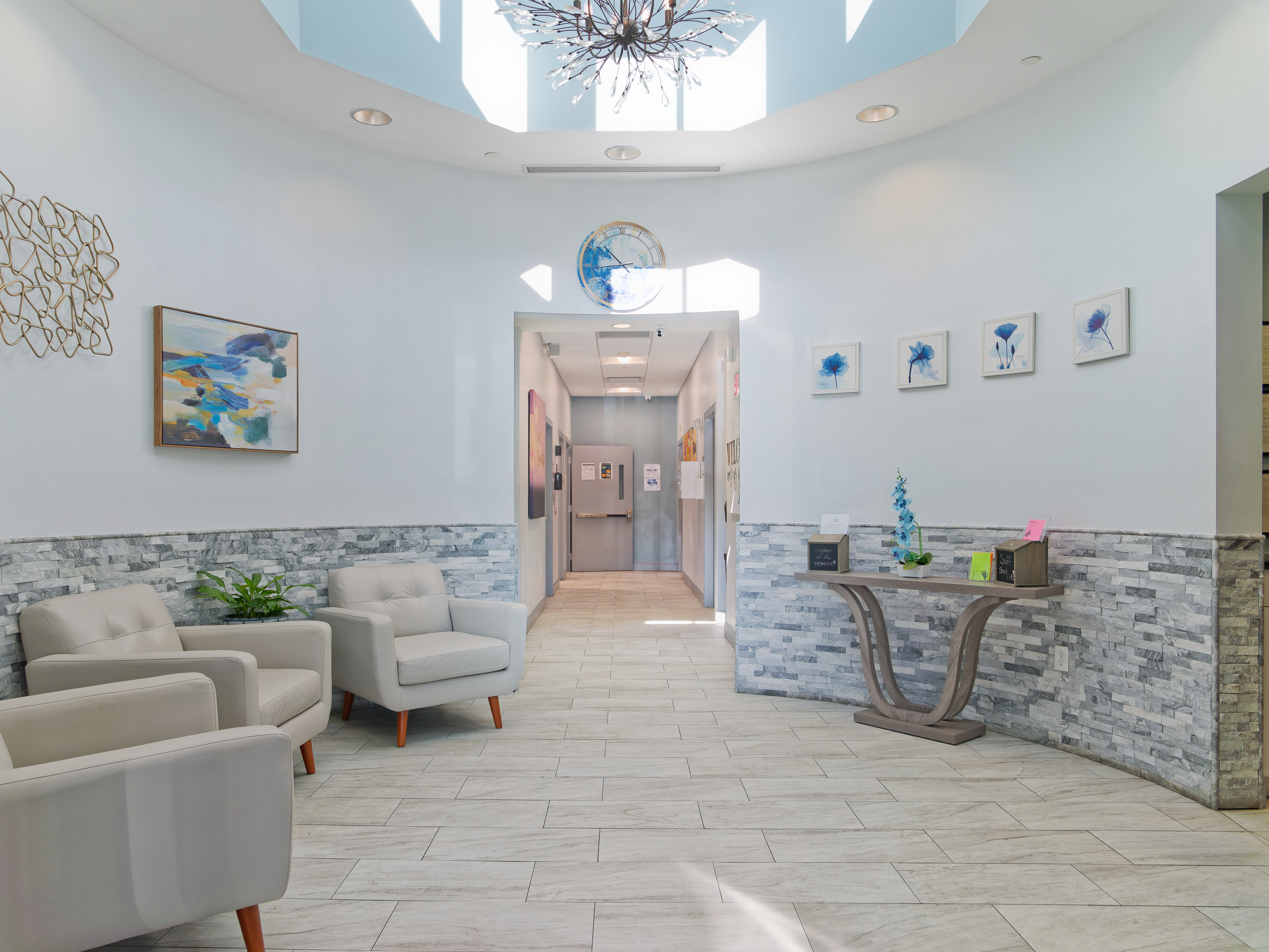 Bright lobby with modern chairs and decorative artwork.