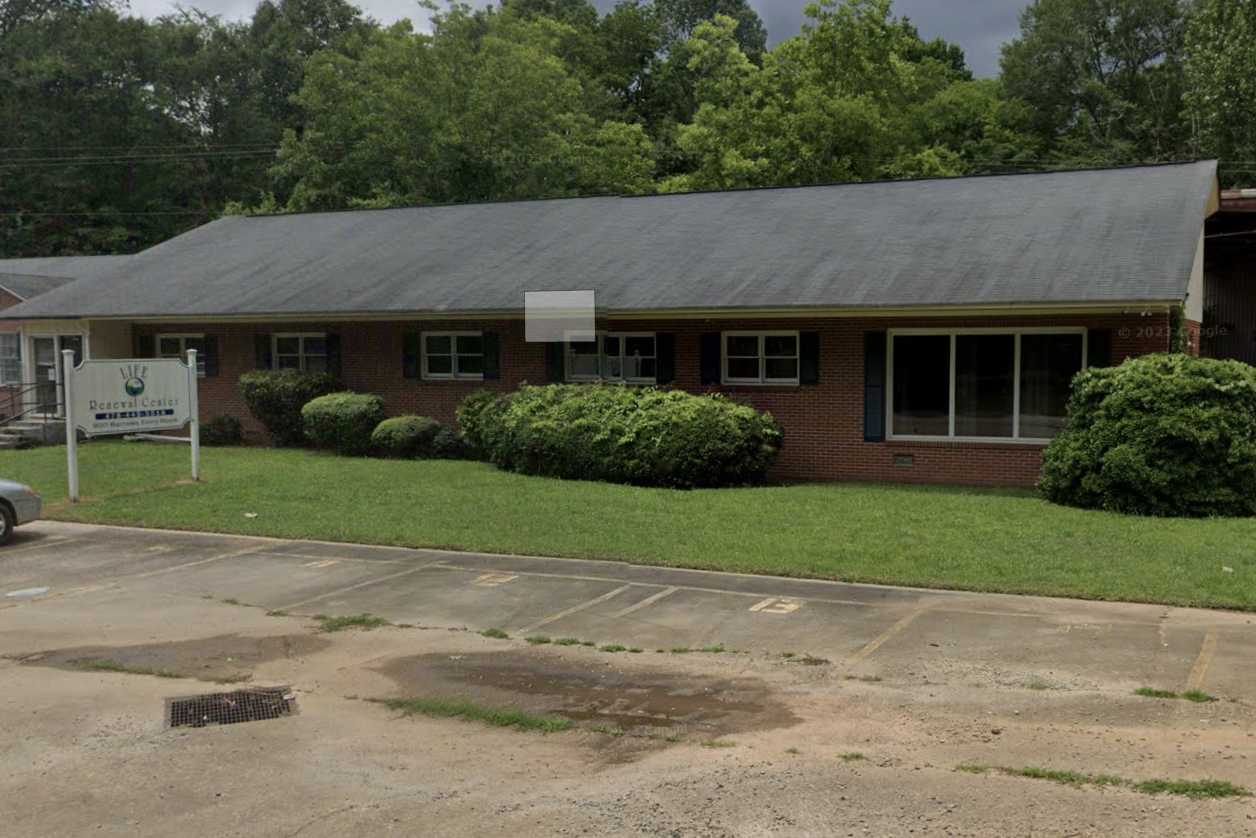Facility sign on lawn outside brick treatment center