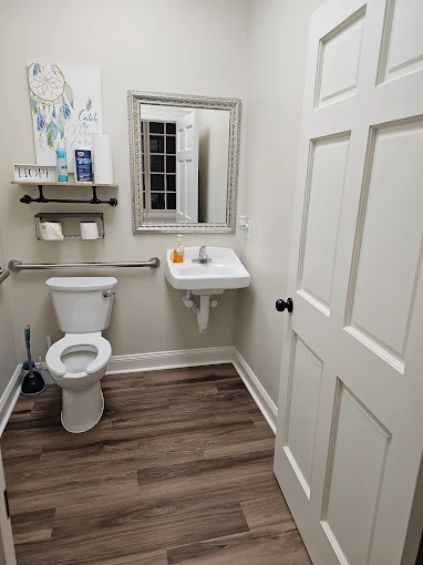Accessible bathroom with toilet, sink, and mirror