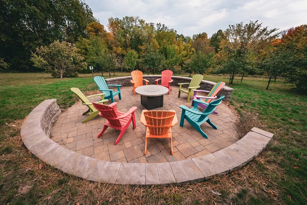 Colorful chairs surrounding an outdoor fire pit patio