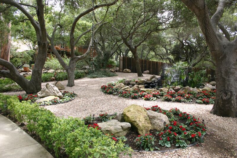 Peaceful garden with flowers, stones, and shaded walking paths