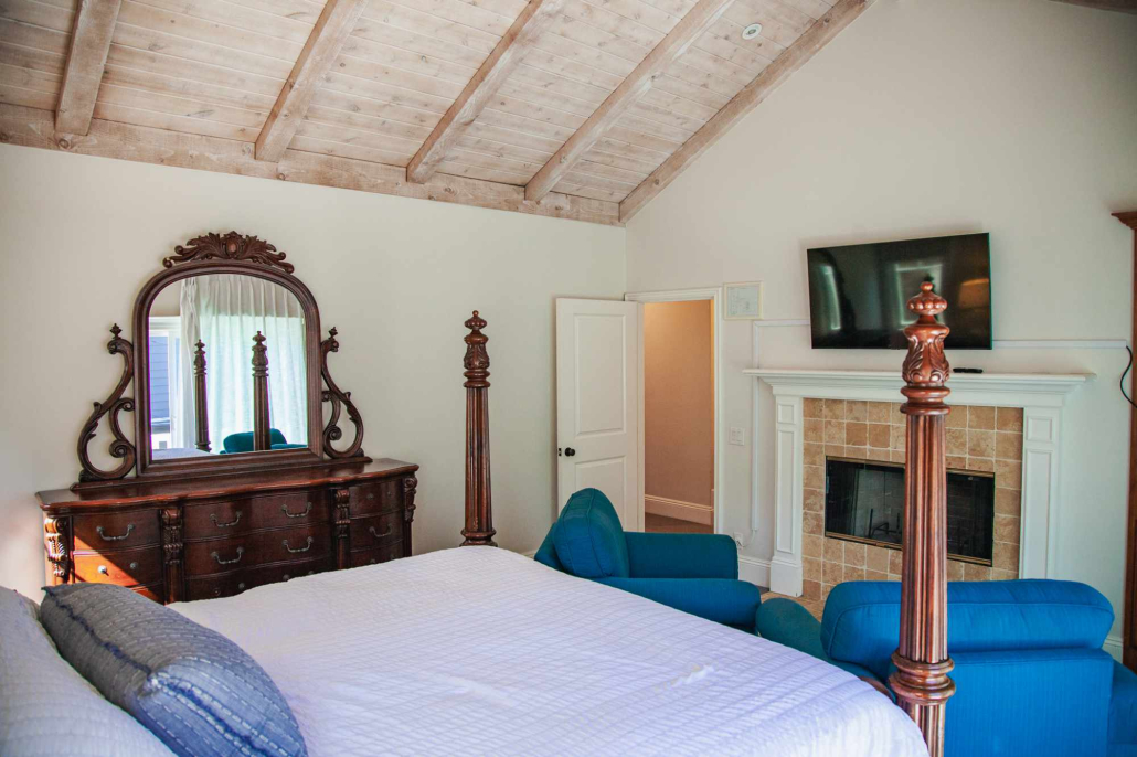 Bedroom with four-poster bed, fireplace, and seating area