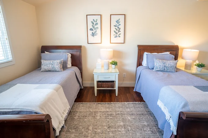 Twin beds with soft linens and nightstand in a bright room