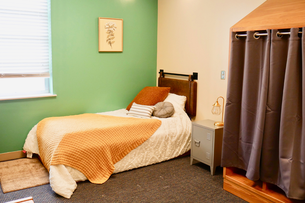 Private bedroom with bed, nightstand, and privacy curtain