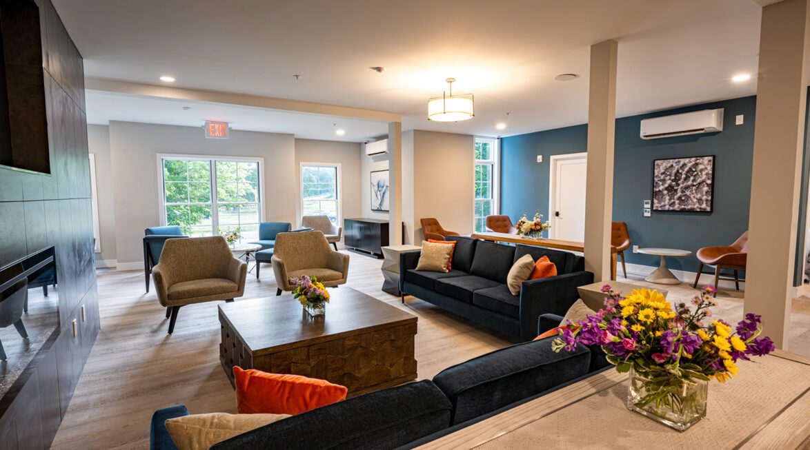 Open-concept community lounge with multiple seating areas and natural light