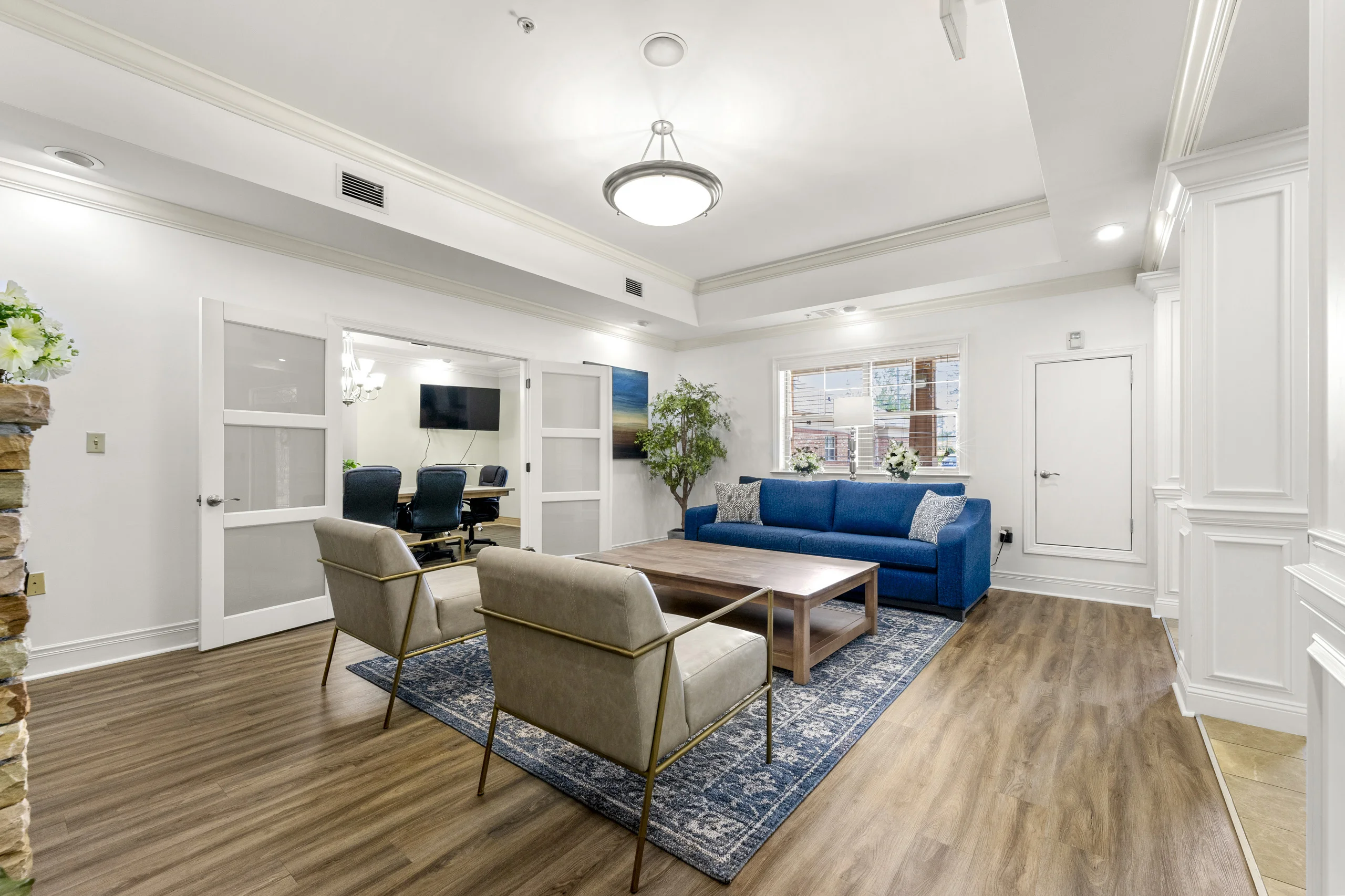 Professional conference room with large meeting table, executive seating, and television for meetings and family sessions