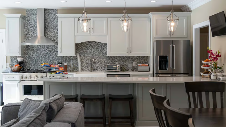 Bright kitchen with bar seating, pendant lights, and stainless fridge