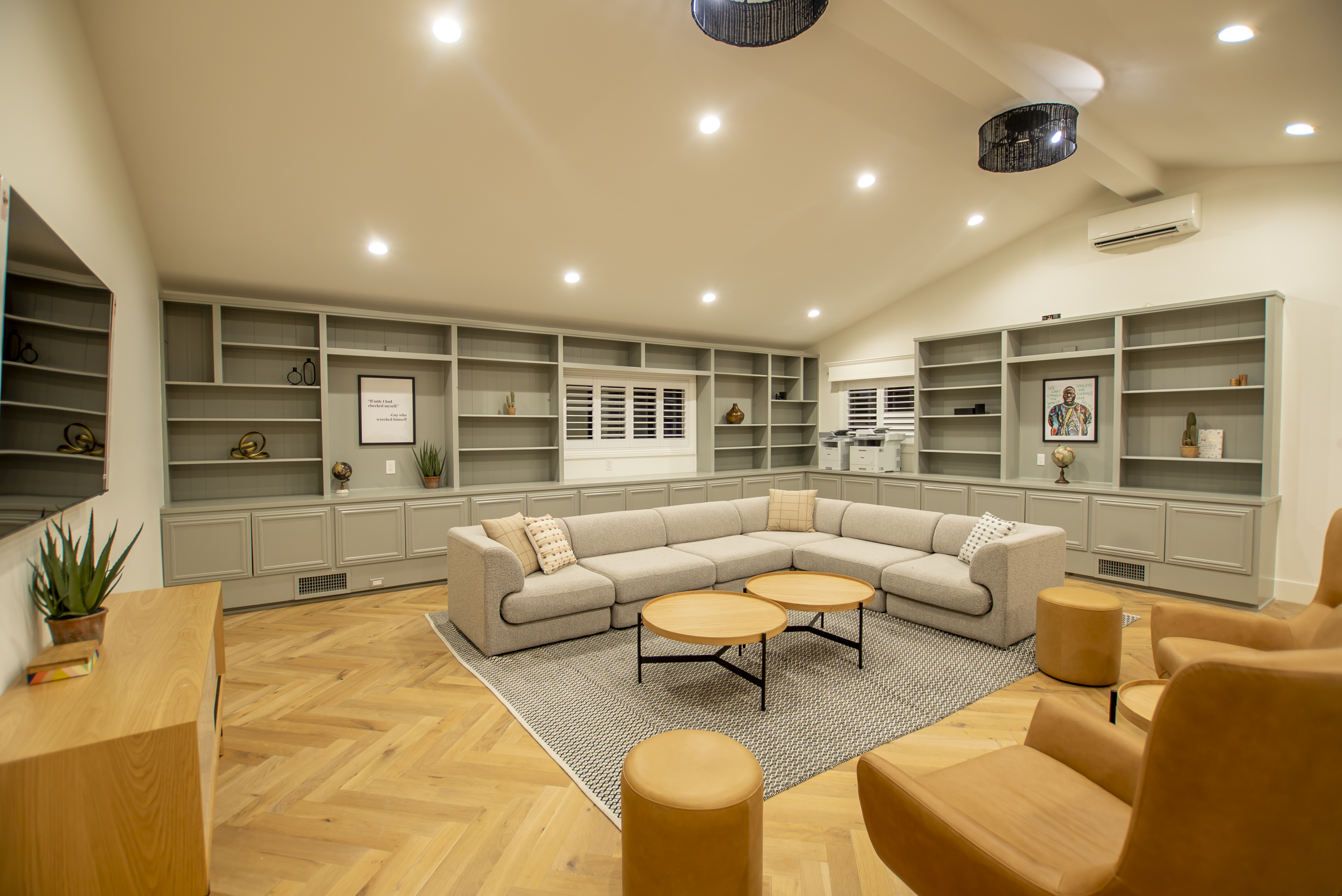 Spacious room with grey sectional and bookshelves