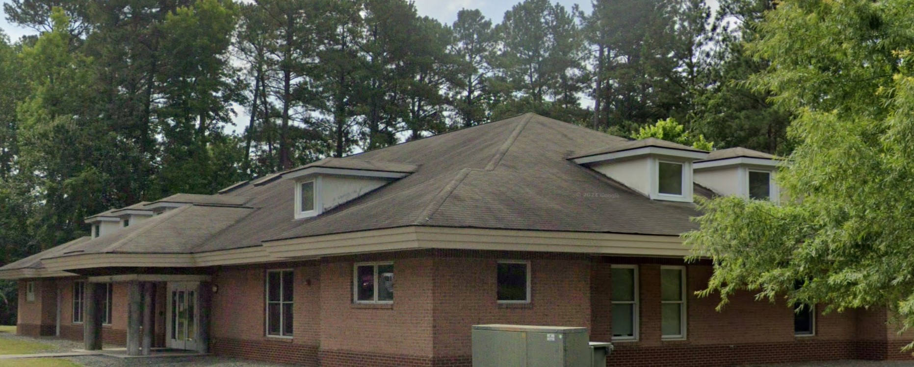 Exterior view of the facility surrounded by greenery.