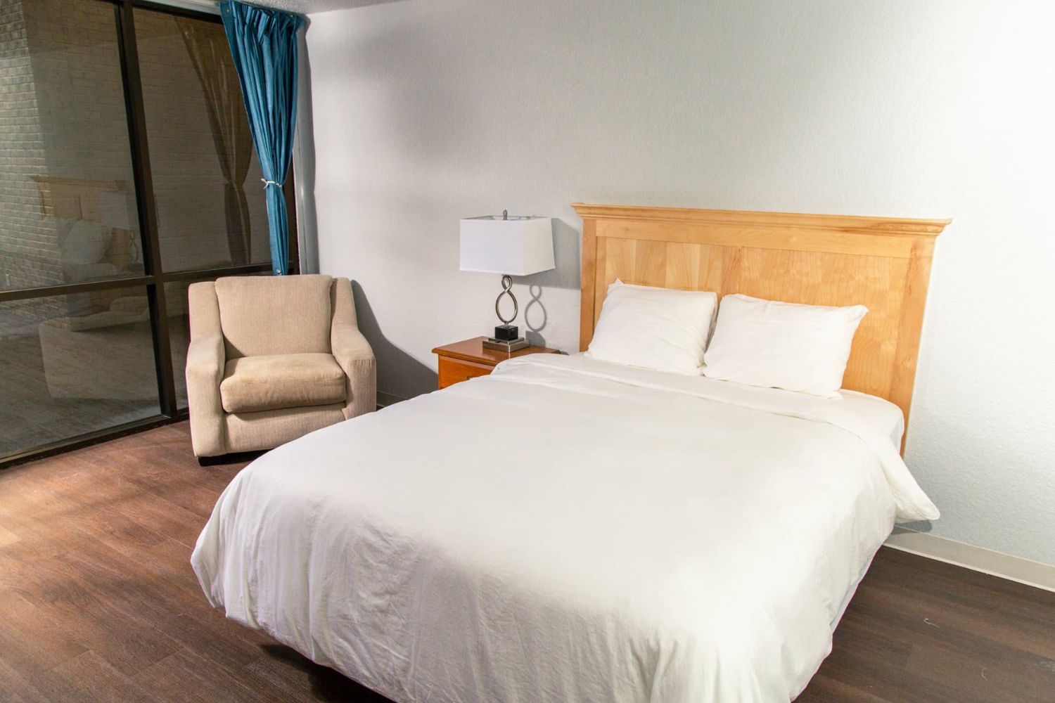 Private bedroom with a bed and and armchair.