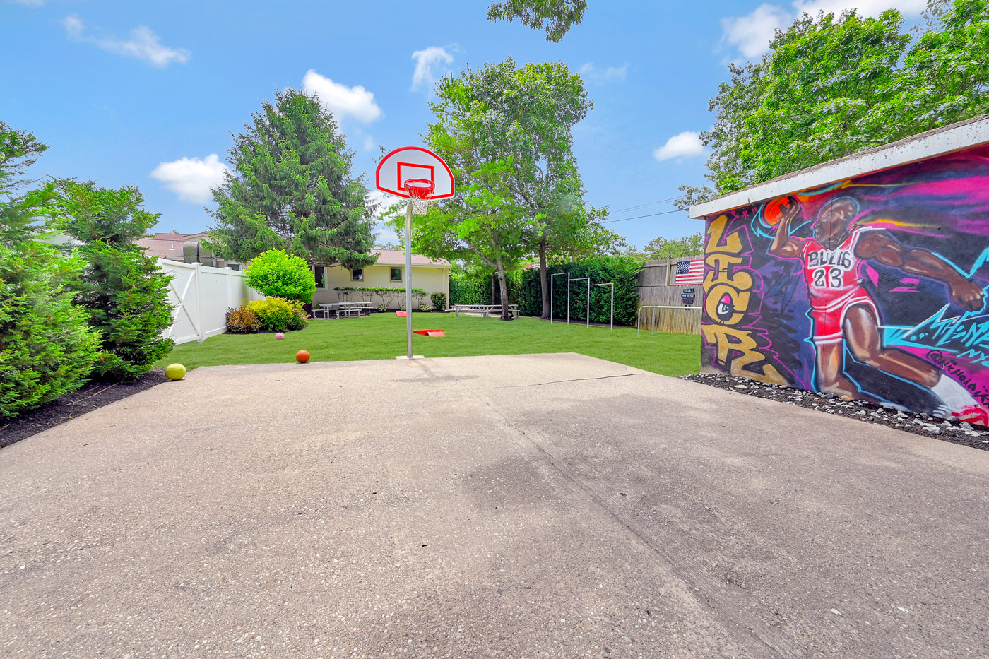 Outdoor basketball area with colorful mural and hoop