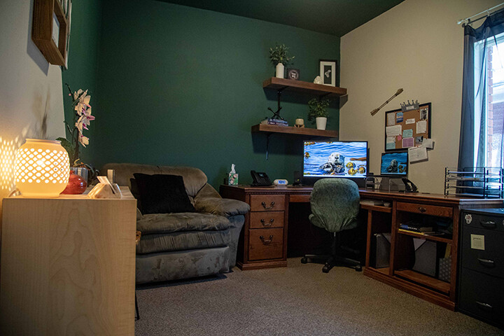 Cozy recreation room with sofa, television, and wooden desk