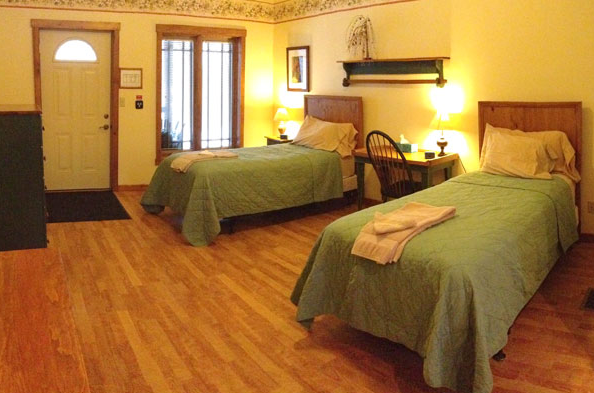 Shared bedroom with two beds and warm lighting at Saint Joseph Institute
