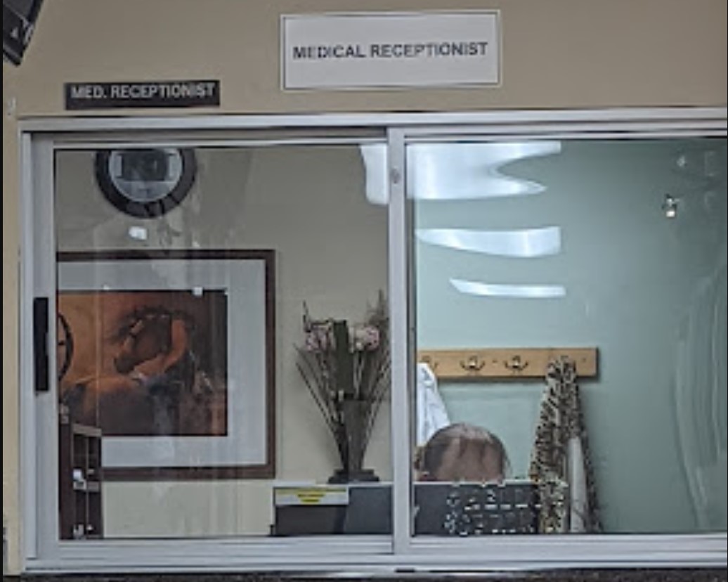 Friendly reception area of Riverside-San Bernardino County Morongo Clinic, featuring a glass window and cozy décor.