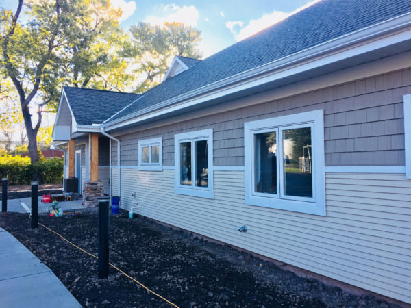 Rehab facility with beige siding and white-framed windows