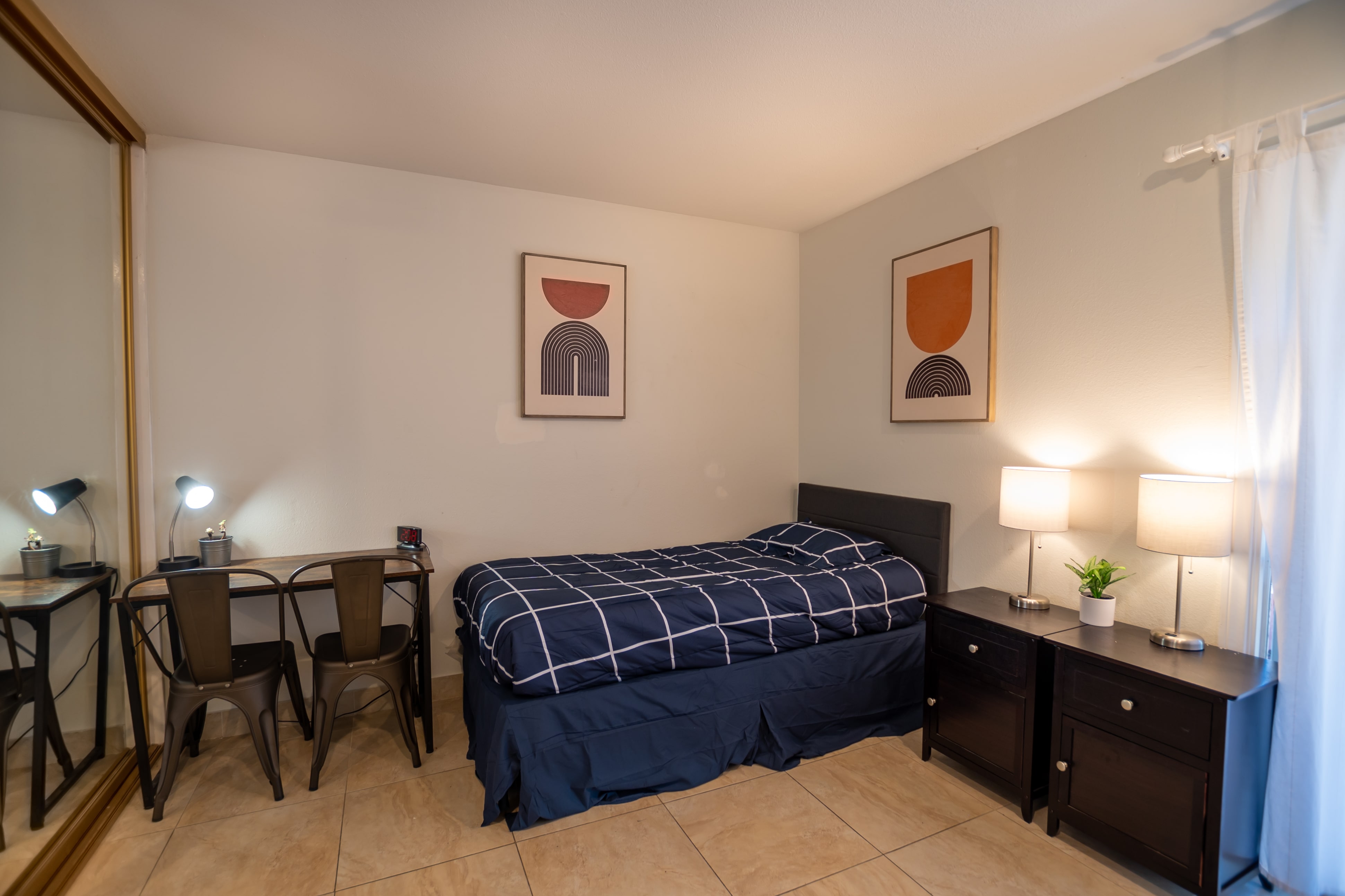 Single bed next to desk and lamps in private room