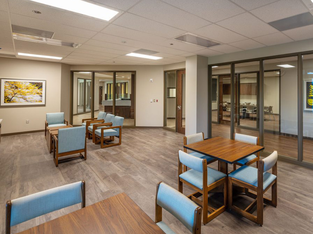 Common area with tables, chairs, and meeting rooms