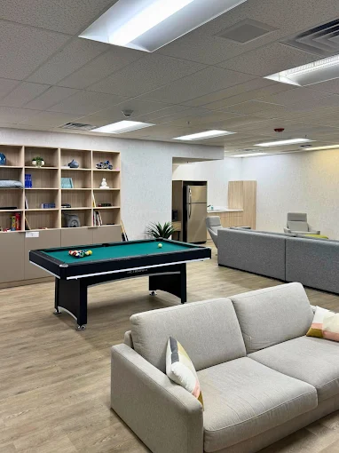 Lounge area with sofas, shelving, and a pool table
