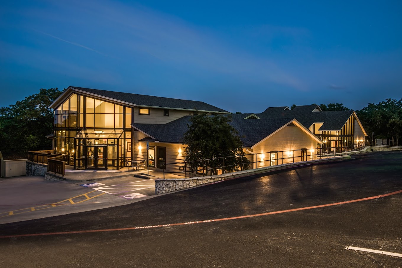 Modern rehab facility with glass walls, lit at night