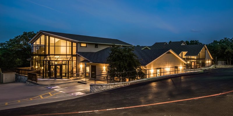 Beautifully illuminated facility at dusk, featuring modern architecture with large windows, creating a warm and welcoming atmosphere.