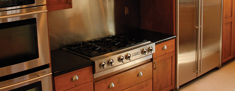Kitchen with stainless steel stove and refrigerator