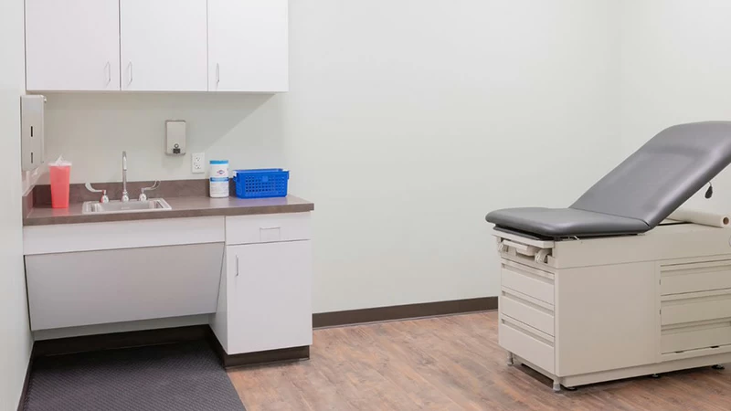 Exam room with sink, cabinets, and exam table