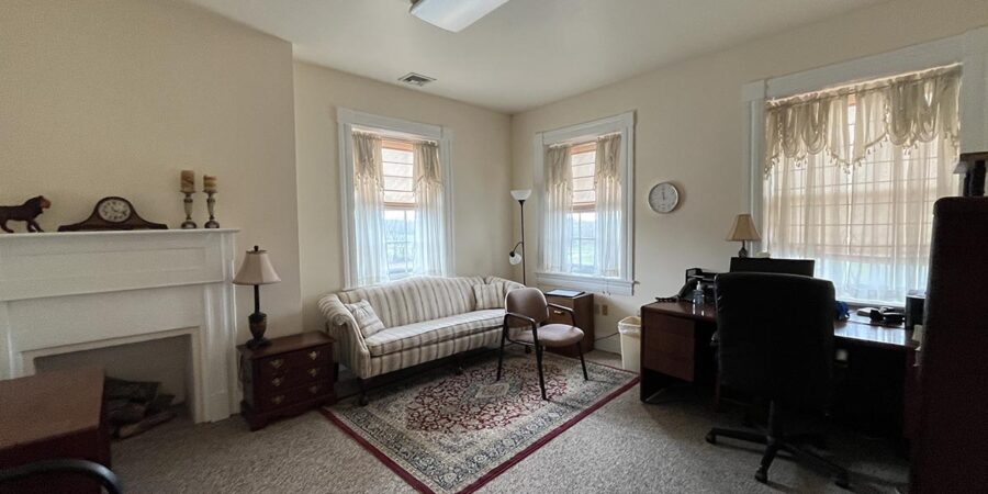 Sofa and desk in office with fireplace