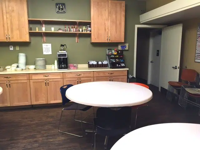 Dining room with round tables and a coffee station at Janus.