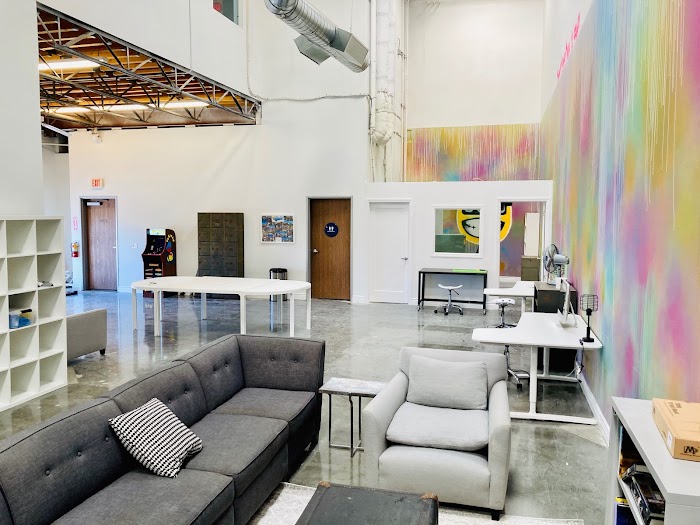 Waiting area with comfortable seating and a colorful wall mural, providing a vibrant space for clients to relax and socialize.