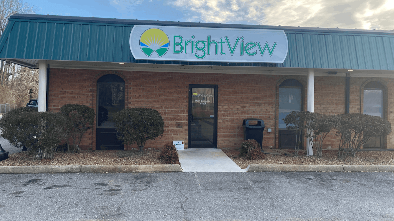 Front exterior of the BrightView Health Lynchburg treatment center with a large BrightView sign above the entrance, brick facade, windows, shrubs, and paved walkway