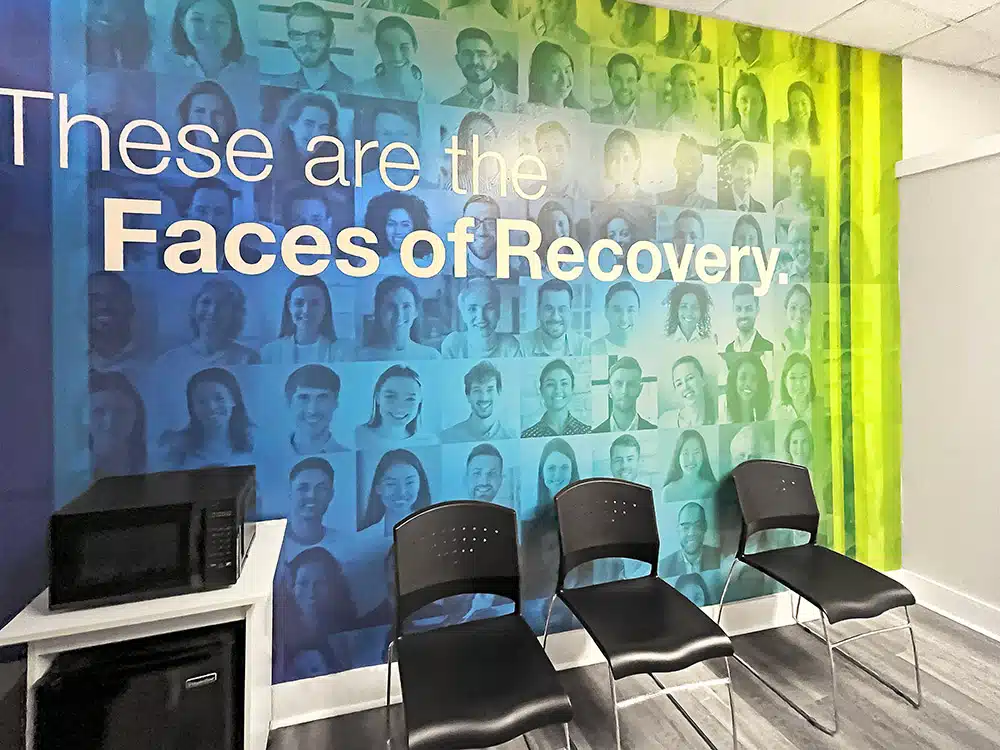 Waiting area with chairs and Faces of Recovery wall mural