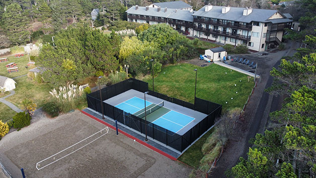Outdoor recreational area with pickleball and volleyball courts.