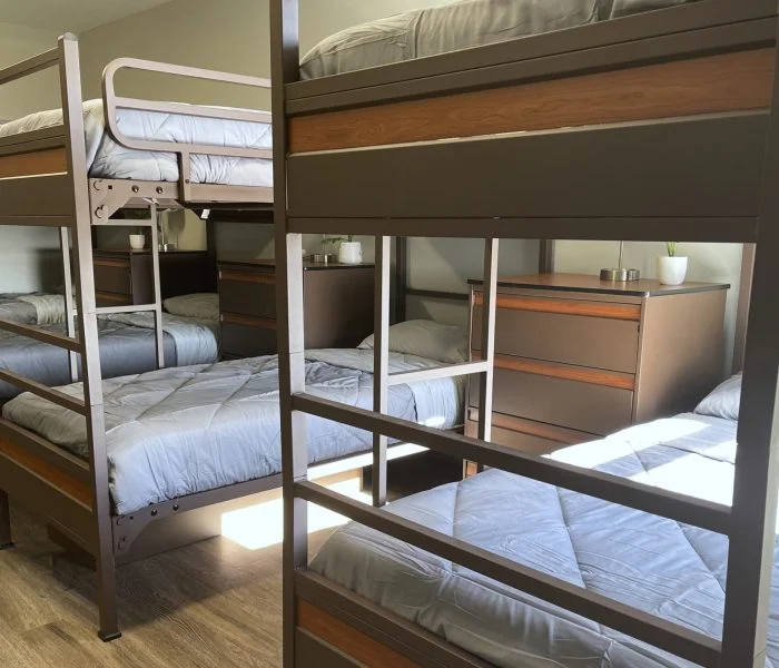Room with multiple bunk beds and dressers