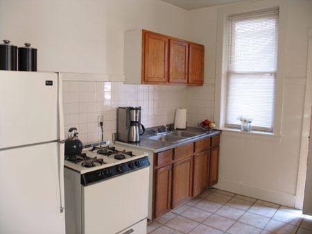 Compact kitchen with stove, fridge, and wood cabinets